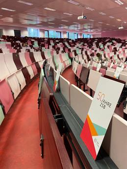 Blick auf die mit Flyern ausgestatteten Sitzreihen im Hörsaal bei der 50-Jahrsfeier